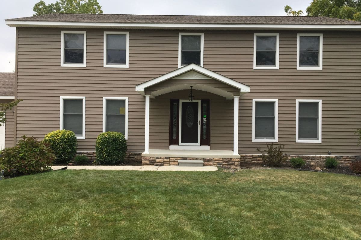 Home exterior showing multiple windows where replacement may be more cost-effective than repeated repairs